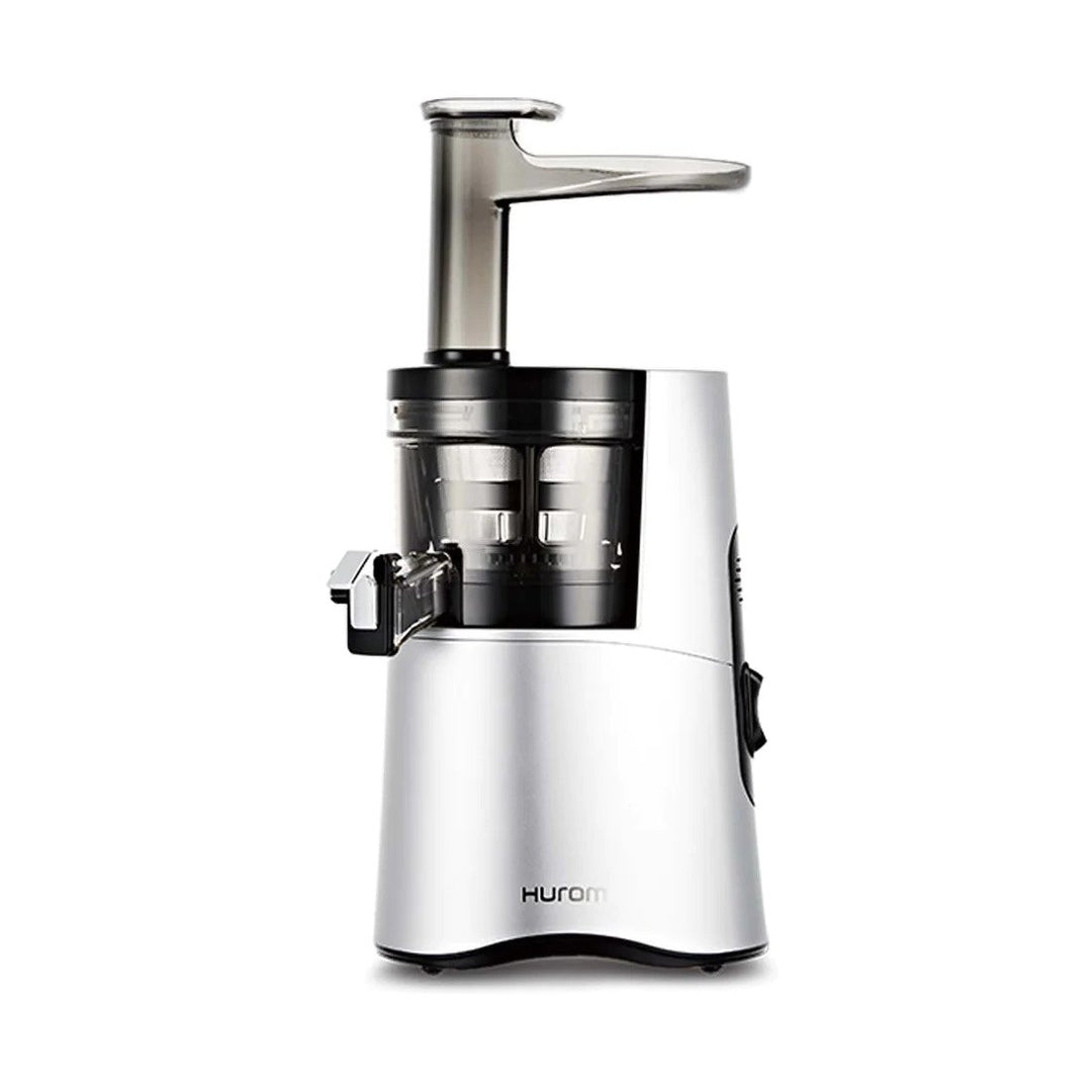 A Hurom HA-2600 Classic Series slow juicer in silver color, showing the juicer's chamber and the pusher.