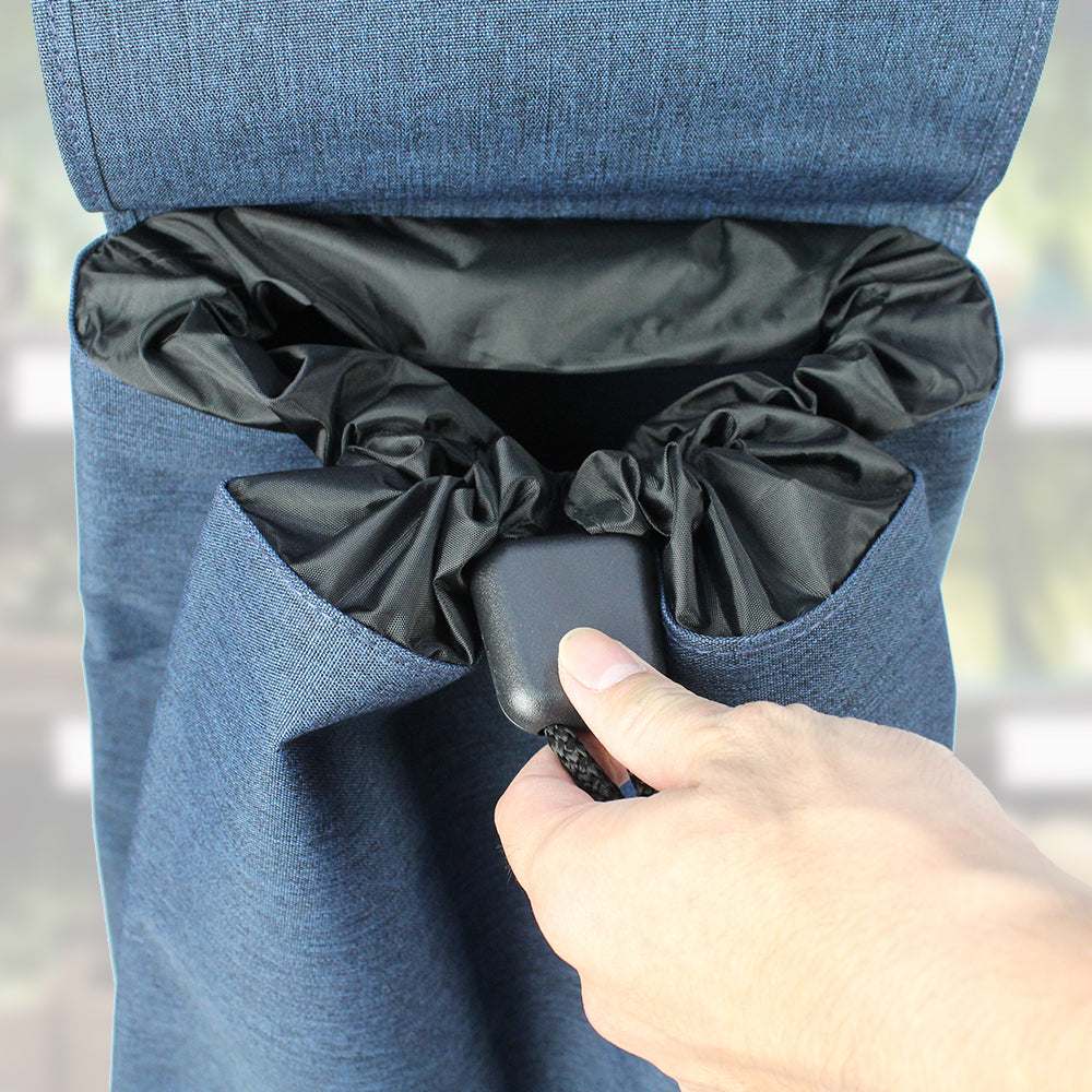 A navy blue Rolser Tweed shopping trolley having the drawstring mechanism being tightened.