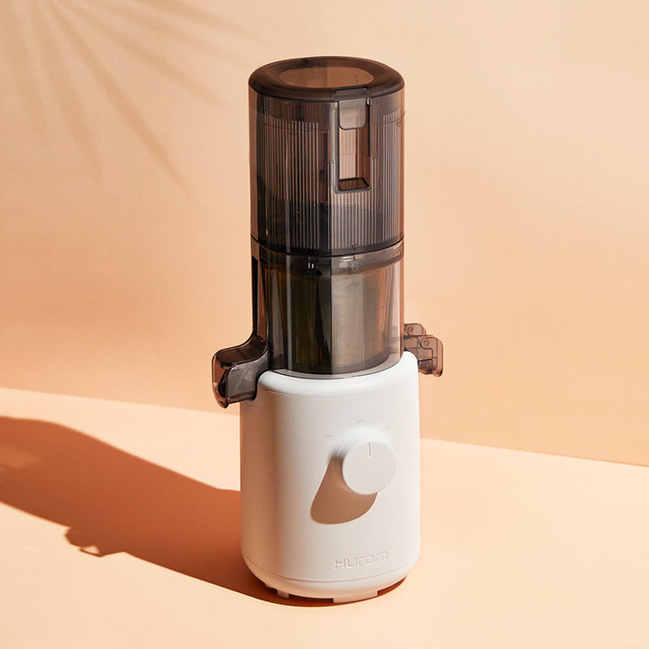 A beige Hurom H-310A Slow Juicer on a table.