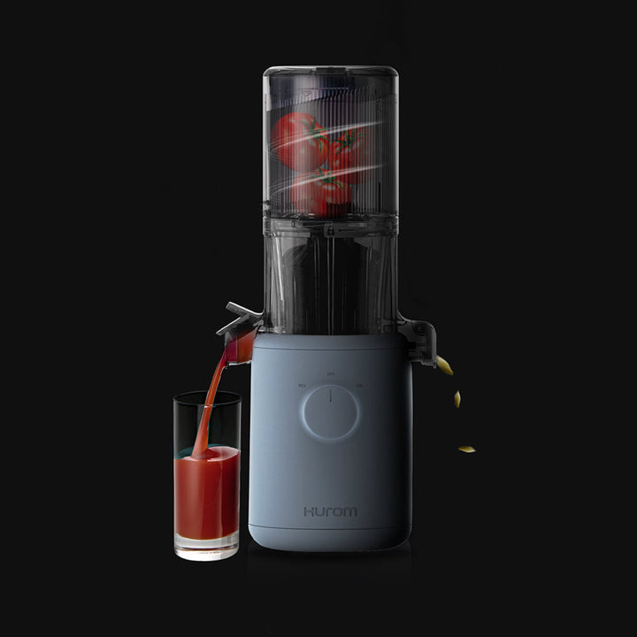 A sky blue Hurom H-310A Slow Juicer releasing juice, with tomatoes filled in the juicer.